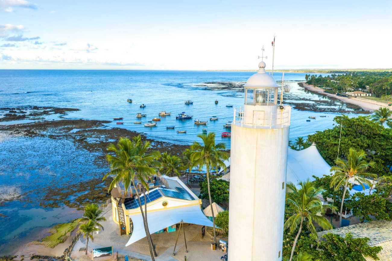 Vista aérea da costa da Praia do Forte, Bahia, com farol ao fundo